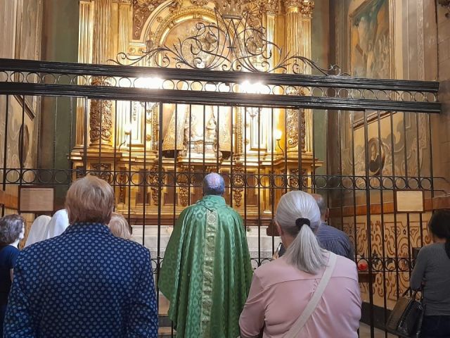 grupo de josefinos y madres ante la imagen de nuestra señora de los desamparados en la basílica de belen en Barcelona.