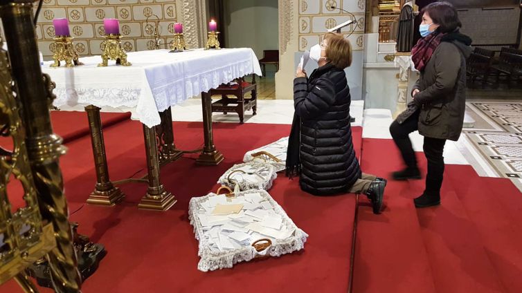 Josefina rezando ante el altar del santuario y las cartas que San José ha recibido.