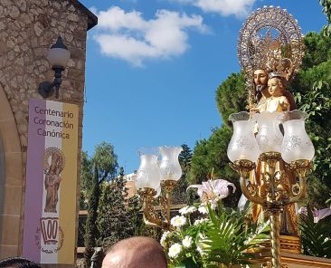 San José de la Montaña procesionando delante del cartel de Centenario.